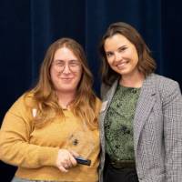 Two women posing with an award